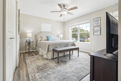 a bedroom with a bed with a ceiling fan and a television at Spacious San Antonio Retreat with Private Patio! in San Antonio