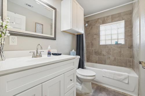 a white bathroom with a sink and a toilet at Spacious San Antonio Retreat with Private Patio! in San Antonio