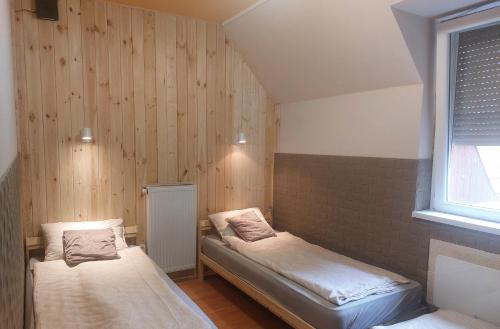 ボガーチにあるTünde Szállásのベッド2台と窓が備わる小さな客室です。