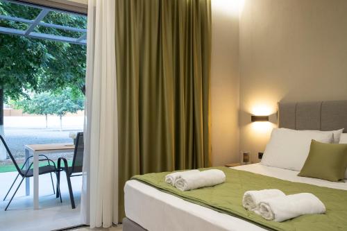 ein Schlafzimmer mit einem Bett mit Handtüchern darauf in der Unterkunft Olympus Suites in Paralia Pantaleimonos