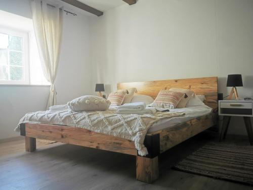 ein Schlafzimmer mit einem großen Holzbett mit Kissen in der Unterkunft Kuća za odmor Iva in Turija