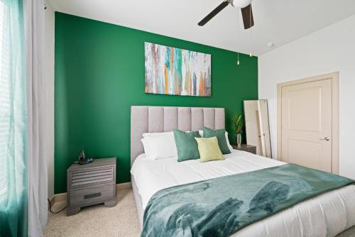 a green bedroom with a bed and a green wall at Packhouse 3 in Houston