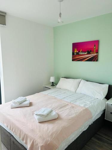 a bedroom with a large bed with two towels on it at Modern 2BR Sleeps 4 Easy Access to City Centre in Manchester