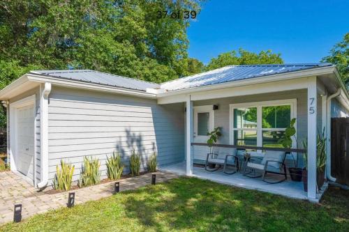 a small white house with a patio at San Sebastiáns Hideaway - Modern with Group Friendly Amenities just minutes from Downtown and St Augustine Beach in Saint Augustine