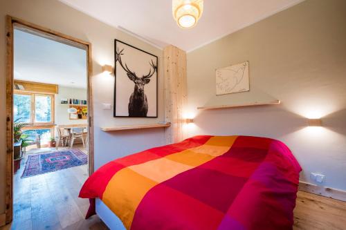 um quarto com uma cama com um cobertor colorido em LA CASA NEL BOSCO 