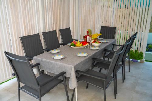a dining room table with chairs and a bowl of fruit at Island house in Psakoudia