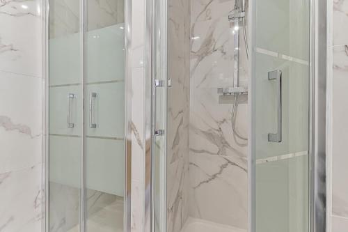 uma casa de banho com um chuveiro e uma porta de vidro em CityStay full brand new appartement 3 bedrooms 5min to Paris em Bagnolet