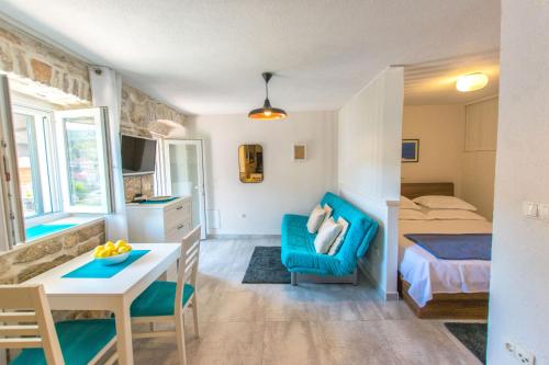 ein Schlafzimmer mit einem blauen Stuhl, einem Bett und einem Tisch in der Unterkunft Apartment Penny in Stomorska