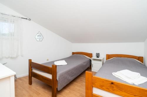 a bedroom with two beds and a desk and a window at House Bany in Skradin
