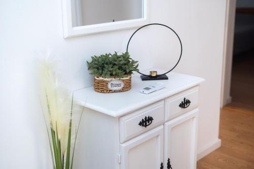 a white cabinet with a mirror and a plant on it at House Bany in Skradin