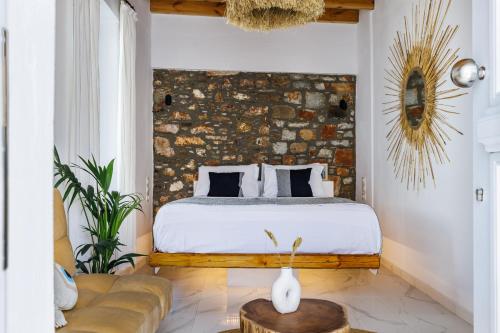 1 dormitorio con cama y pared de ladrillo en Traditional House, en Skopelos Town