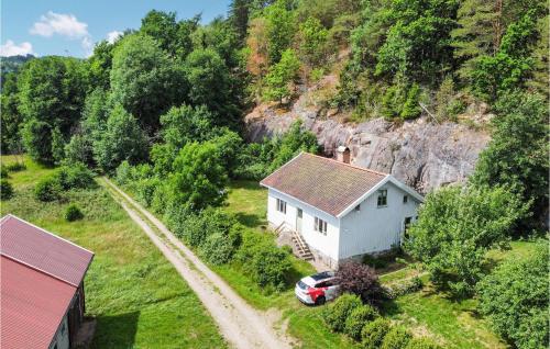 a white house with a car parked next to a road at 1 Bedroom Cozy Home In Lysekil in Lysekil