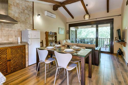 a kitchen and living room with a table and chairs at Apartamentos rurales Alameda del Jerte in El Torno