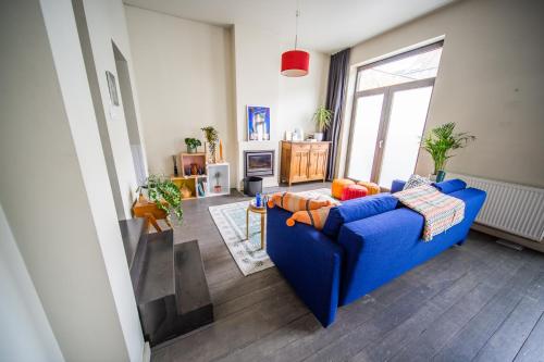 een woonkamer met een blauwe bank en een raam bij Casa Mina - Dok Noord Ghent in Gent