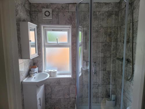 a bathroom with a shower and a sink and a window at Comfy one bedroom flat in Tilehurst