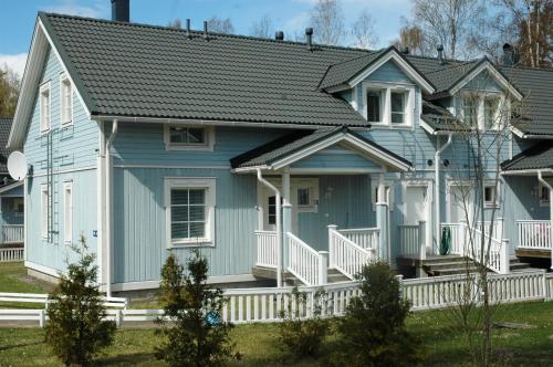a blue house with a white porch at Holiday Houses Saimaa Gardens in Imatra