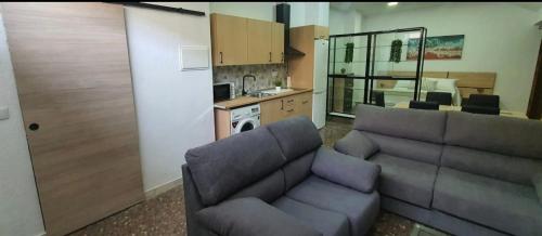 sala de estar con sofá y cocina en APARTAMENTO TURISTICO GUADIANA LOFT EXPERIENCE Dalia en Badajoz