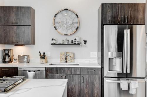 a kitchen with wooden cabinets and a clock on the wall at New Ski In Out Luxury Loft #201 With Hot Tub, Gym & Great Views - 500 Dollars Of FREE Activities & Equipment Rentals Daily in Winter Park