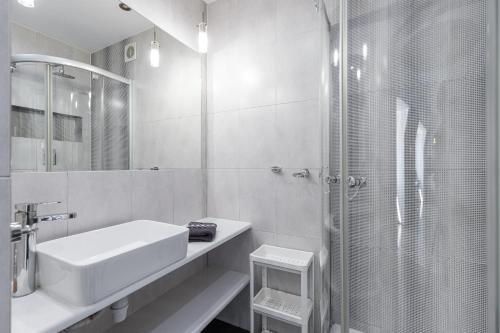 biała łazienka z umywalką i prysznicem w obiekcie Prywatne studio dla 4 osób z widokiem na Rynek i Plac Solny! we Wrocławiu