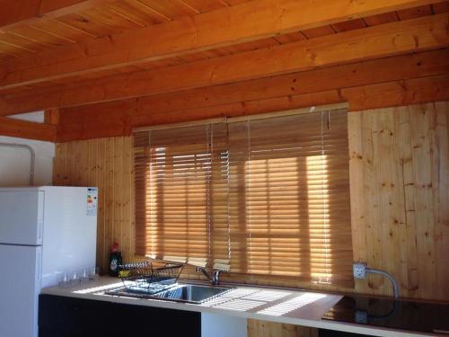 una cocina con fregadero y una ventana con paredes de madera. en Half wooden rural apartment, en Fasnia