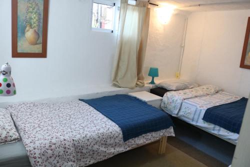1 dormitorio con 2 camas y ventana en Half wooden rural apartment, en Fasnia