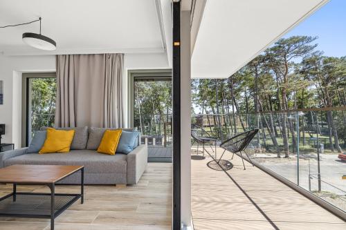 a living room with a couch and a table at Solaris Darłówko Premium Emilia Strupiechowska in Darłowo