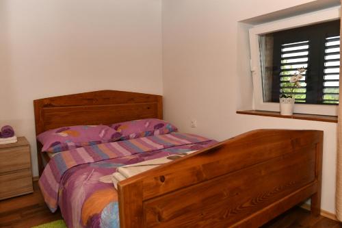 een slaapkamer met een houten bed en een raam bij Great place for relaxation in Gornji Proložac