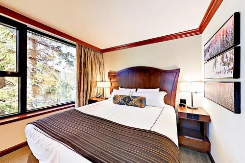 a bedroom with a large bed and two windows at Resort at Everline Resort & Spa #560 in Olympic Valley