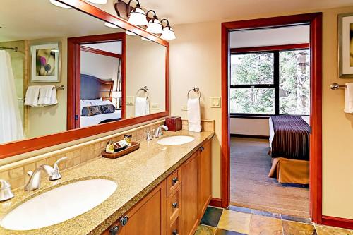 a bathroom with two sinks and a large mirror at Resort at Everline Resort & Spa #560 in Olympic Valley