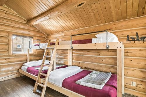 a bedroom with two bunk beds in a log cabin at Chum Salmon in Soldotna