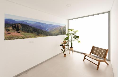 Habitación blanca con banco y pintura en la pared en Sun House - Alojamento Local - Ponte de Lima en Ponte de Lima