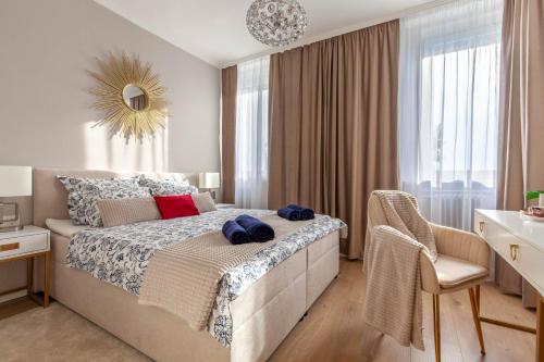 a bedroom with a bed and a chair and a window at SMARAGD-Emerald in Veszprém