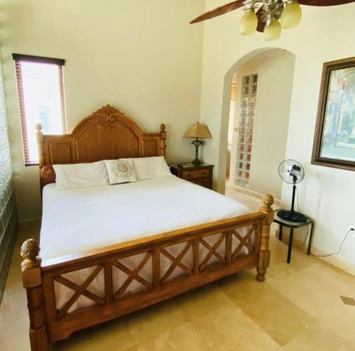 um quarto com uma cama de madeira num quarto em Beach Front Condo steps from beach em Six Huts