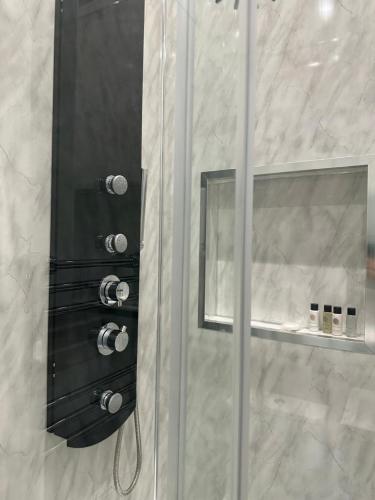 a shower with a glass door and a mirror at Thistle City Inn in Edinburgh