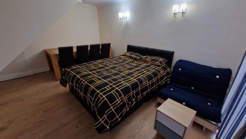 - une petite chambre avec un lit et une chaise dans l'établissement Rooms Shared Kitchen FREE Parking, à Slough