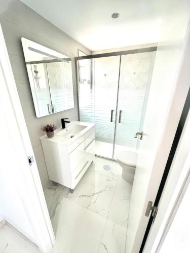 biała łazienka z umywalką i toaletą w obiekcie Apartamento Benidorm Rincón de Loix w mieście Benidorm