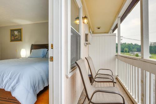 een slaapkamer met een bed en 2 stoelen op een balkon bij Nifty Fayetteville Vacation Rental Near New River! in Fayetteville