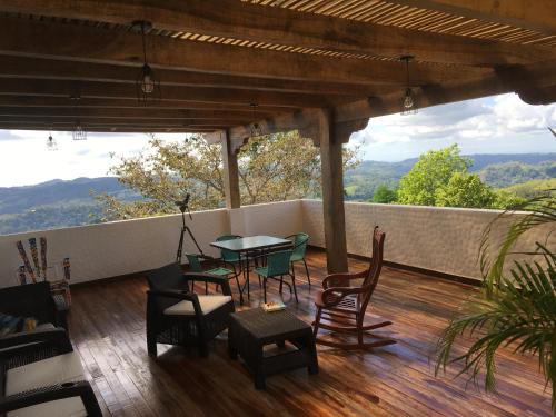 a patio with a table and chairs on a deck at Hacienda Las Vainillas Boutique Hotel in Mastatal