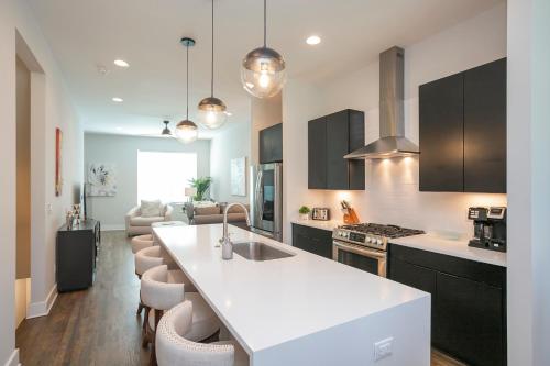 a kitchen with a white counter top and a living room at Luxury Townhome Skyline Views Mins To DT in Nashville