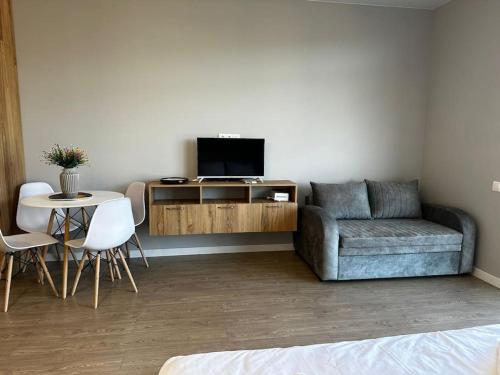 ein Wohnzimmer mit einem Sofa und einem Tisch mit einem TV in der Unterkunft Nessy's Apartment 