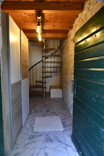 a hallway with a green door and a staircase at Great place for relaxation in Gornji Proložac