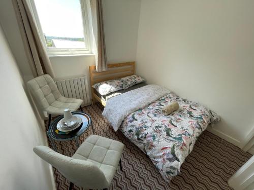 a small bedroom with a bed and a chair at Nottingham Home Stay in Nottingham