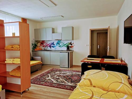 a room with a bed and a desk and a kitchen at Comenius Apartments - Apartmány na rohu in Svidník