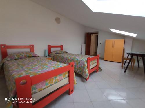 a bedroom with two beds and a table and a table at Casa vacanza Ospedaletto d'Alpinolo in Ospedaletto dʼAlpinolo