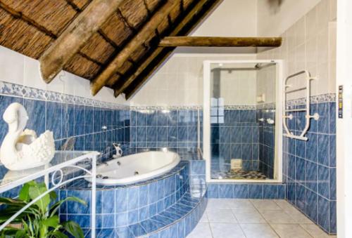 a blue tiled bathroom with a sink and a shower at Mead, Pinelands in Cape Town