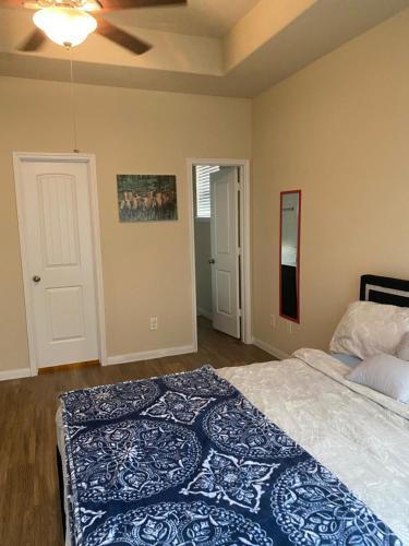 een slaapkamer met een bed en een plafondventilator bij Kenny Place Park row Katy, Texas in Katy
