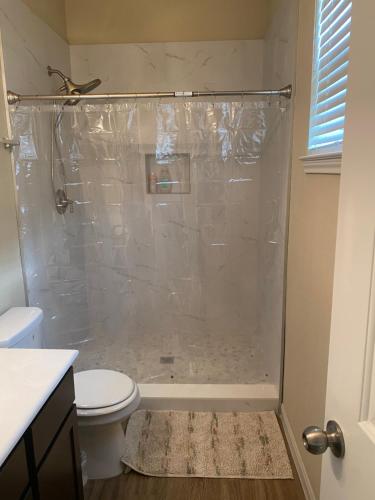 een badkamer met een douche en een toilet bij Kenny Place Park row Katy, Texas in Katy
