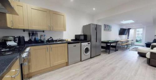 a kitchen with a stove and a refrigerator in a room at Myrtle villa 10 bedrooms sleeps 28, 2 min to beach in Weymouth