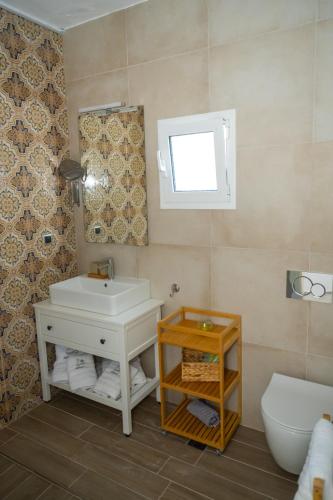 a bathroom with a sink and a toilet and a mirror at Island house in Psakoudia