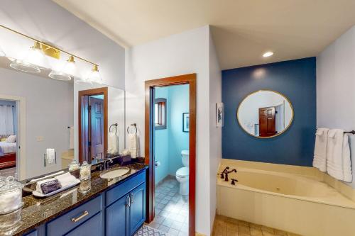 a bathroom with a tub and a sink and a mirror at Abruzzi - Villa A in Eatonton 